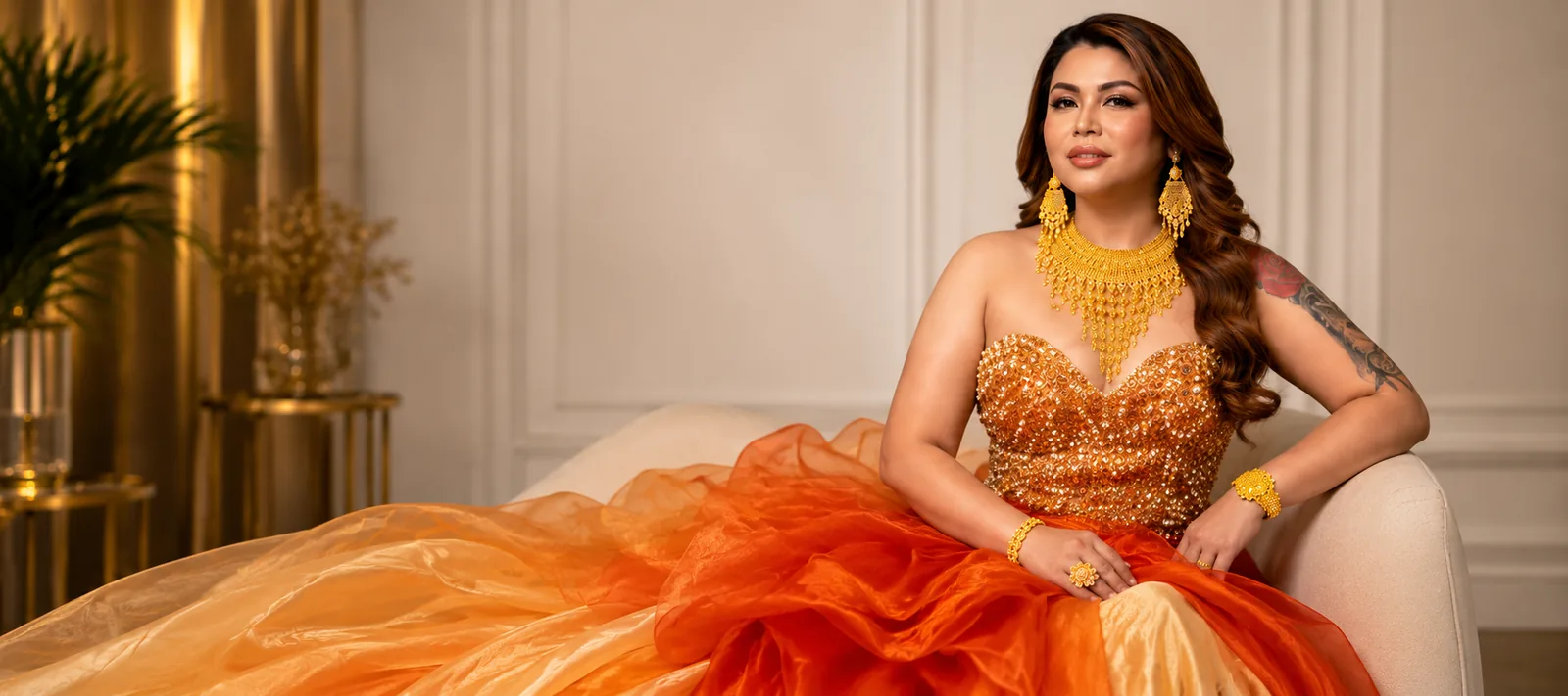 Miss Kim model in a gold gown wearing a 21K necklace, bangles and ring